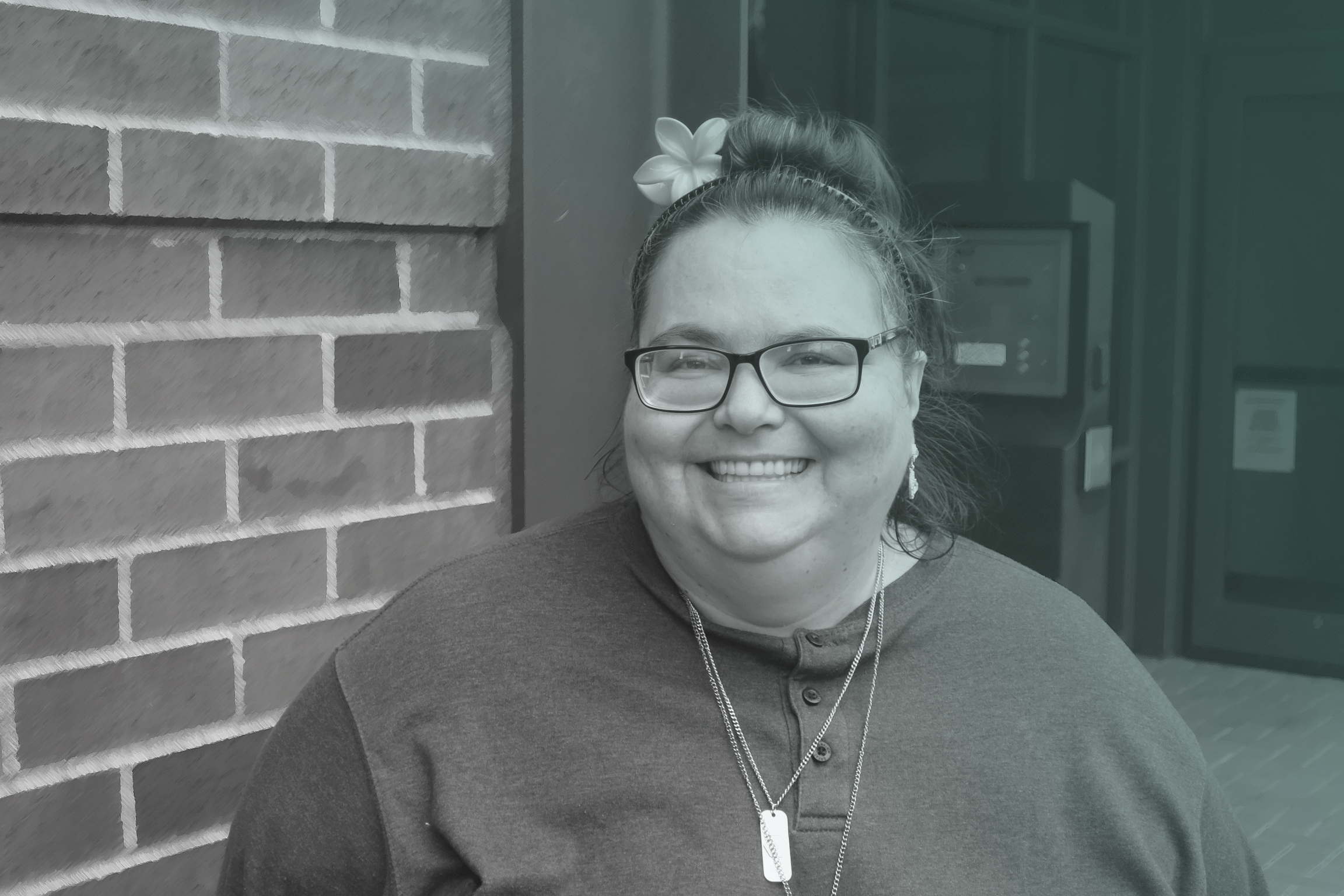 A female smiles standing outside of a brick building