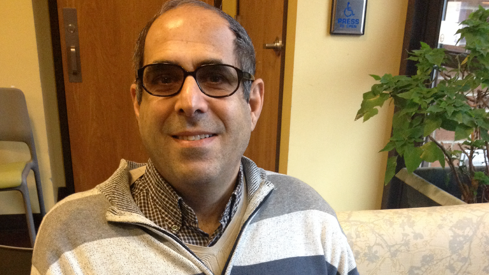 Maybelle Center member, Sassan, sits in our Community Room facing the camera