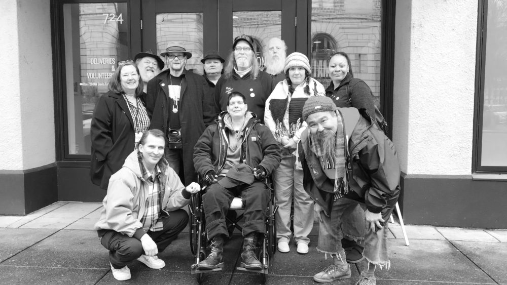 A group of happy people standing in front of a building