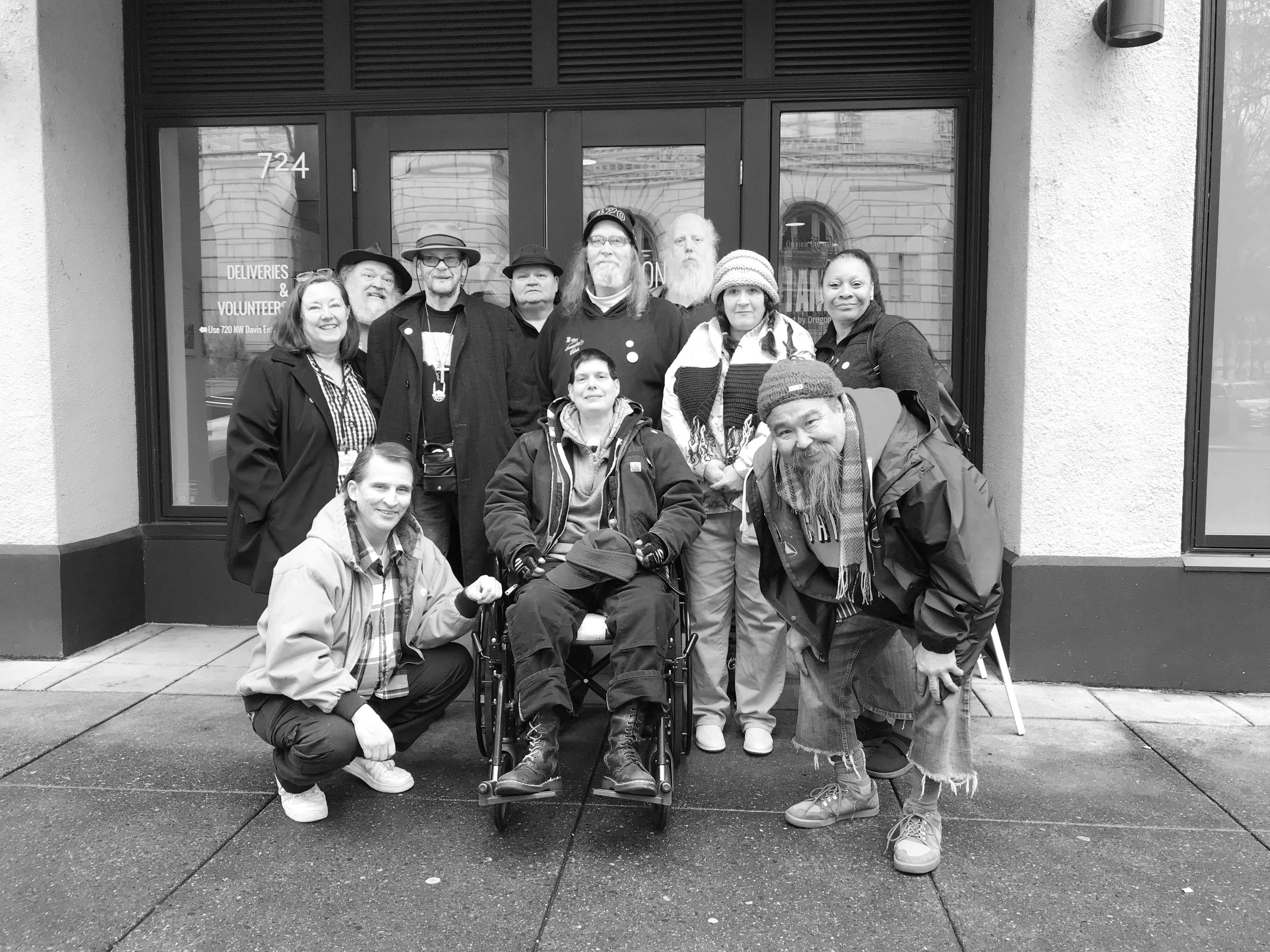 A group of happy people standing in front of a building