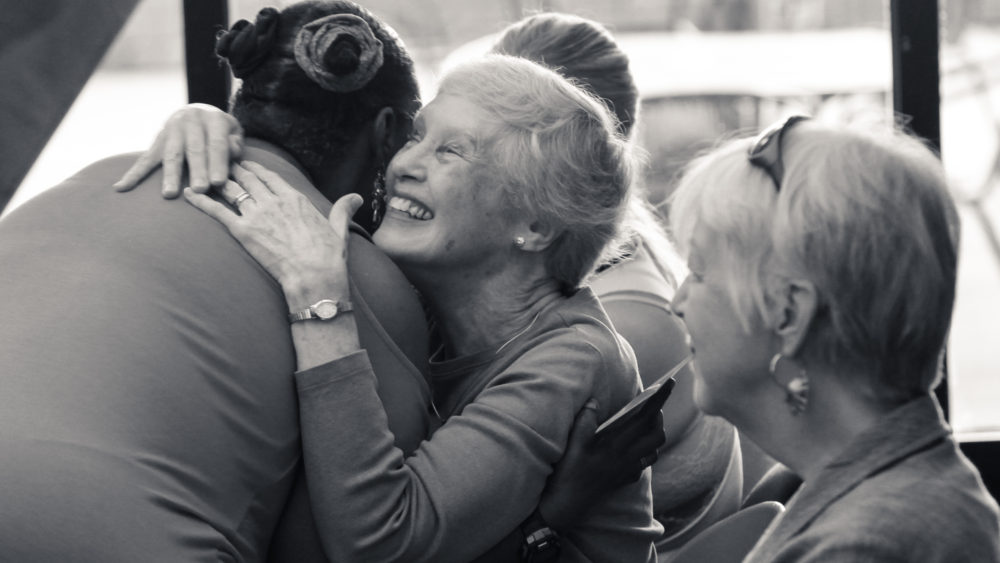 A volunteer and member hug joyfully