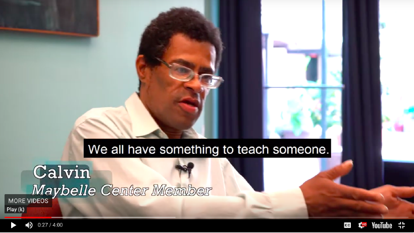 A middle-age, African-American man with glasses and dark hair caught in the middle of conversation