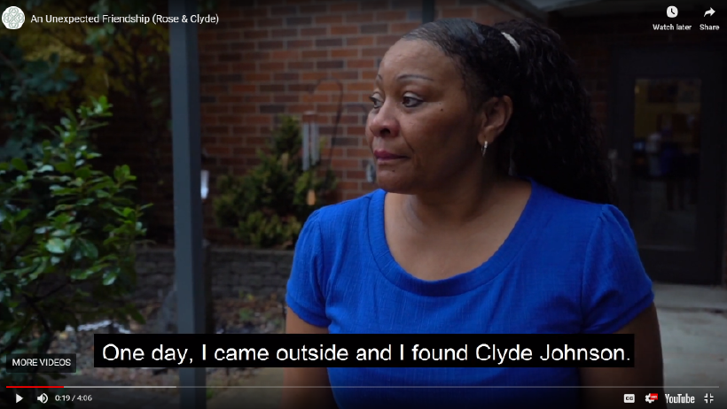 A middle-age African American woman outside with a brick wall in the background