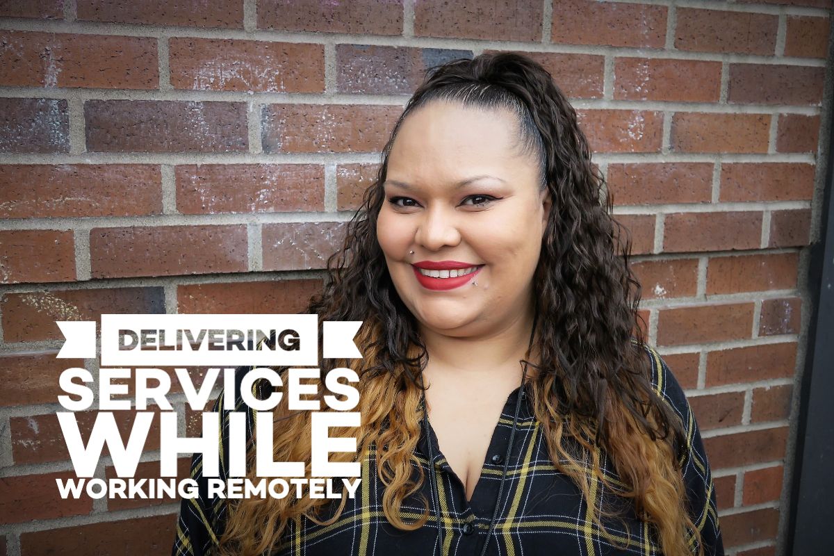 Smiling female with long black hair standing in front of a brick wall with the text "Delivering services while working remotely"