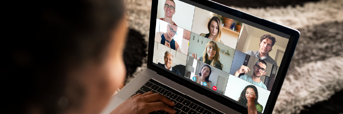 A woman pointing at computer screen at one of the participants in a video call