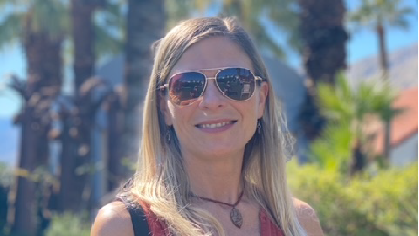 A blonde female with sunglasses, looking at you and smiling