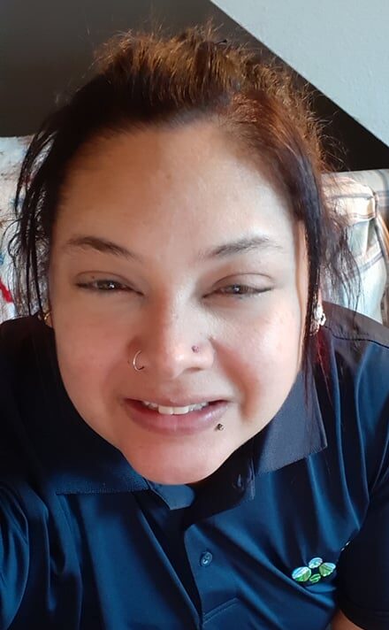 Woman holding camera close to their face, smiling into it